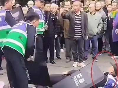 ​闹大了！城管持“防爆盾”推搡卖鱼商贩，两名城管躺地观看引争议